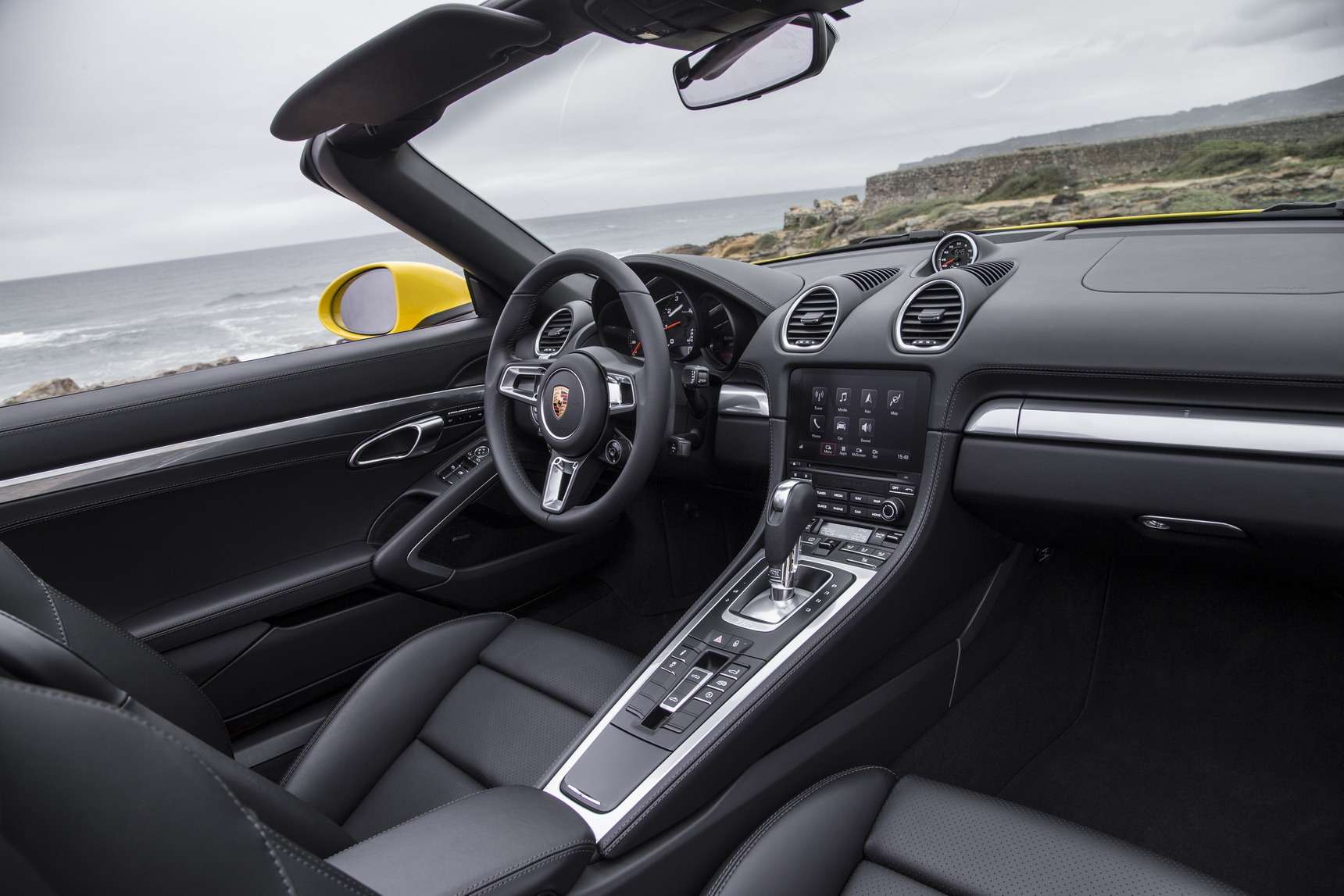 Интерьер 718-й от салона предшественника отличают дефлекторы иной формы да мультимедийная система Porsche Communication Management с сенсорным экраном, вошедшая в базовое оснащение всех новых Porsche Boxster. За навигационный модуль придется доплатить.